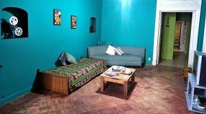 ein blaues Wohnzimmer mit einem Sofa und einem Tisch in der Unterkunft Colonial in San Antonio de Areco