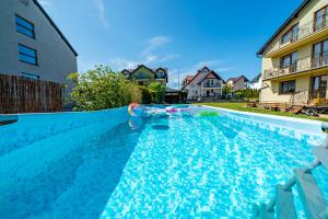 a swimming pool with a person in the water at Willa Rossa in Władysławowo