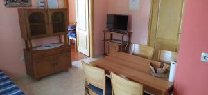 a dining room with a wooden table and a tv at Apartments Ivka in Omiš
