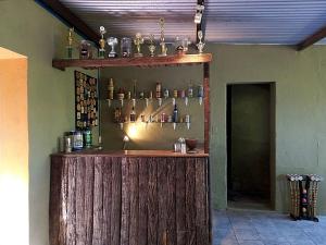 een houten bar met flessen aan de muur bij Colonial in San Antonio de Areco
