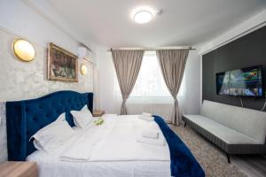1 dormitorio con 1 cama azul y 1 sofá en SIA Residence, en Otopeni