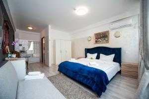 1 dormitorio con 1 cama grande con manta azul en SIA Residence, en Otopeni