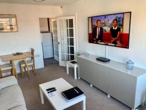 a living room with a flat screen tv on a wall at NEW Superb One Bedroom Getaway in Dysart Kirkcaldy in Kirkcaldy