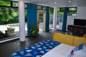 a bedroom with a bed and a living room at Suite 9, Manuel Antonio in Quepos