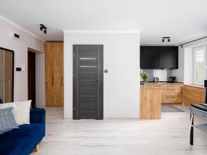 a living room with a blue couch and a kitchen at VISTULA Grand two-bedroom Apartment ul Okrzei in Płock