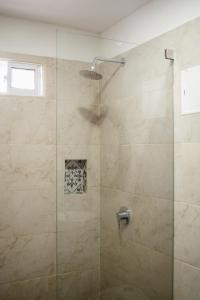 a bathroom with a shower with a glass door at Hotel ADAZ Mediterráneo in Santa Marta
