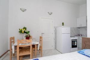 a kitchen with a table and a white refrigerator at Apartmani Bar in Bar +4 photos
