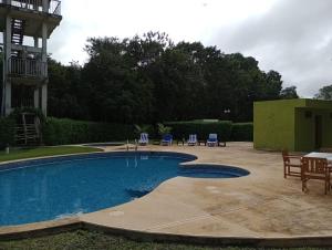 a swimming pool in a yard with chairs and a table at chicanna ecovillage resort in Chicanna