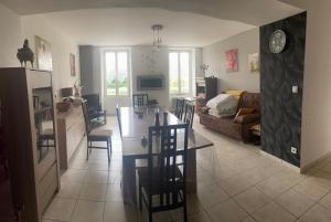 a kitchen and living room with a table and chairs at Au Château Saint Blaise in Virignin