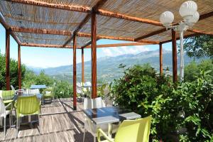 a patio with a table and chairs and a view of mountains at La Palatriere in Le Sauze-du-lac