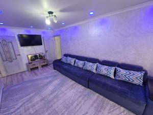 a purple living room with a blue couch in a room at Апартамент Плаза in Shymkent