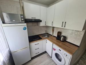 a small kitchen with a white refrigerator and a washer at Апартамент Плаза in Shymkent