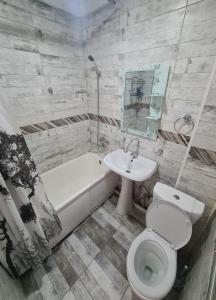W łazience znajduje się umywalka, toaleta i wanna. w obiekcie Апартамент Плаза w mieście Szymkent