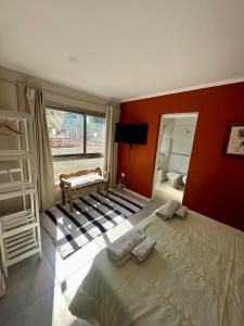 a bedroom with a bed and a red wall at POSTA 20 - Cálido apartamento temporario! in Salta