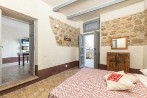 a bedroom with a bed and a stone wall at Antico Forno Baunei in Baunei