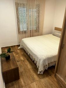 a bedroom with a bed and a potted plant at Apartman Hana in Brtonigla