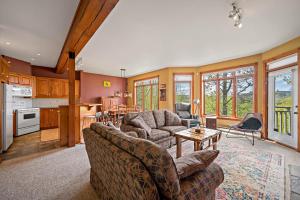 ein Wohnzimmer mit 2 Sofas und einer Küche in der Unterkunft Chalumeau by Rendez-Vous Mont- Tremblant in Mont-Tremblant