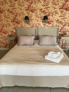 a bed with two pillows and two towels on it at Belle Fontaine in Bourges