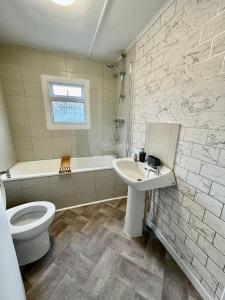 a bathroom with a toilet and a sink and a tub at Whittams Hot-tub Chalet Retreat in Heysham