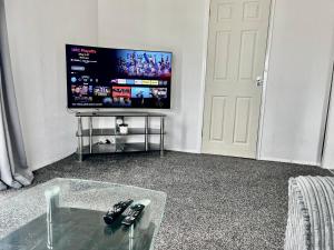 a living room with a tv and a glass table at Whittams Hot-tub Chalet Retreat in Heysham