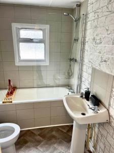 een badkamer met een bad, een wastafel en een toilet bij Whittams Hot-tub Chalet Retreat in Heysham