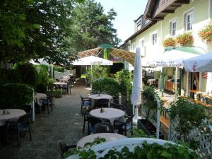 an outdoor restaurant with tables and umbrellas at Hotel Kohlpeter in Salzburg