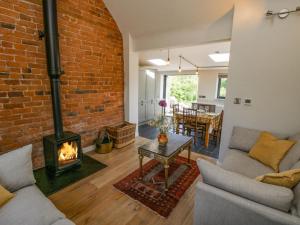 a living room with a brick wall and a fireplace at The Mission Room in Malpas