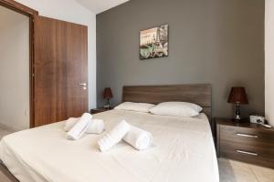 een slaapkamer met een groot wit bed met 2 kussens bij SLIEMA Love-Hosted by Sweetstay in Sliema