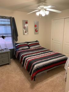 a bedroom with a bed and a ceiling fan at Large Modern Residence with private guest, family room & business office in Missouri City