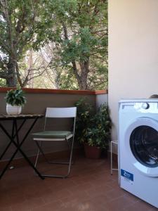 lavadora y silla junto a una mesa en La casa di Ieia, en Porto Ercole