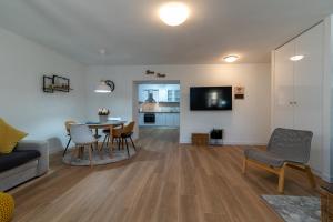 ein Wohnzimmer mit Sofa, Tisch und Stühlen in der Unterkunft Apartman Benzon Vranjic in Vranjic