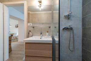 ein Badezimmer mit Waschbecken und Dusche in der Unterkunft Apartman Benzon Vranjic in Vranjic + 29 Fotos