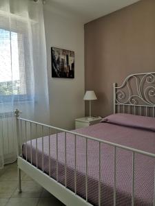 Un dormitorio con una cama con sábanas moradas y una ventana en La casa di Ieia, en Porto Ercole