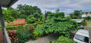 a garden with a car parked in a driveway at Lynn's Getaway Apartments in Apia