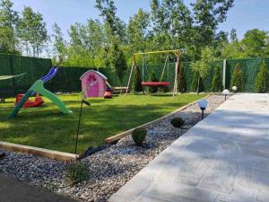 un patio trasero con parque infantil y equipo de juegos en Vikendica Una na Drini en Loznica