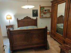 1 dormitorio con cama de madera y espejo en Raphael house, en Gubbio