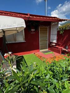 een rood huis met een tuin ervoor bij la casina rossa B&B "Da capachiatta" in San Sebastiano al Vesuvio
