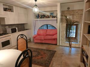 a living room with a red couch in a kitchen at Raphael house in Gubbio