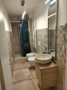 bagno con 2 lavandini, servizi igienici e doccia di Raphael house a Gubbio
