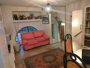ein Wohnzimmer mit einem roten Sofa und einem Tisch in der Unterkunft Raphael house in Gubbio