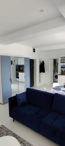 a living room with a blue couch and a bed at Euphoria Neptun Oxygen in Neptun