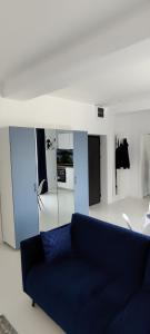 a living room with a blue couch and mirrors at Euphoria Neptun Oxygen in Neptun