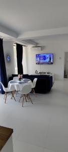 a living room with a table and chairs and a tv at Euphoria Neptun Oxygen in Neptun