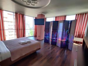 ein Schlafzimmer mit einem großen Bett und einigen Fenstern in der Unterkunft Micromegas apartments in Czernowitz