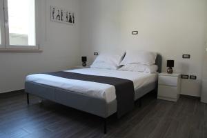 um quarto com uma cama grande com lençóis brancos e uma janela em Dimora Due Galli em Ponti Sul Mincio