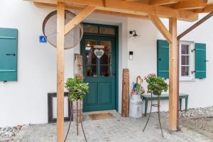 Lisbeth في روتينبوخ: باب أخضر على منزل به طاولة وكراسي