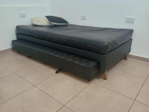 a black bed with a pillow on top of it at CENTENO CASI 9 DE JULIO in Santa Rosa