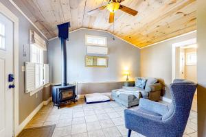 un soggiorno con camino, divano e sedia di Tannery Brook Cottage a Bucksport