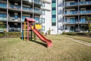 a playground with a slide in front of a building at Swiss Green Appartement Cosy et Spacieux in Quarteira