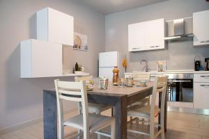 a kitchen with a wooden table and white cabinets at Il sole di calde Lago maggiore 504 in Castelveccana
